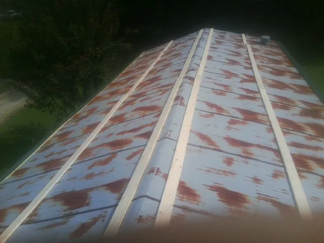 Rusted metal roof panels with new wood purlins before replacement — Storm Damage Roof Repair in Pentwater by Roofing Brothers