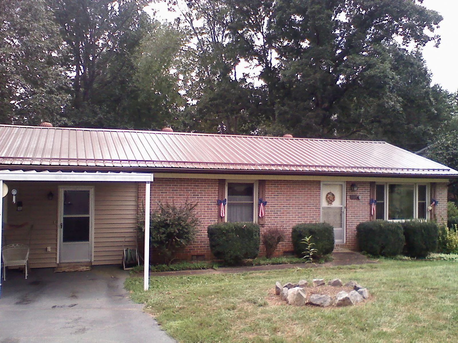 Bronze metal roof and carport on a brick ranch home — Roof Repair work by our crew in Pentwater