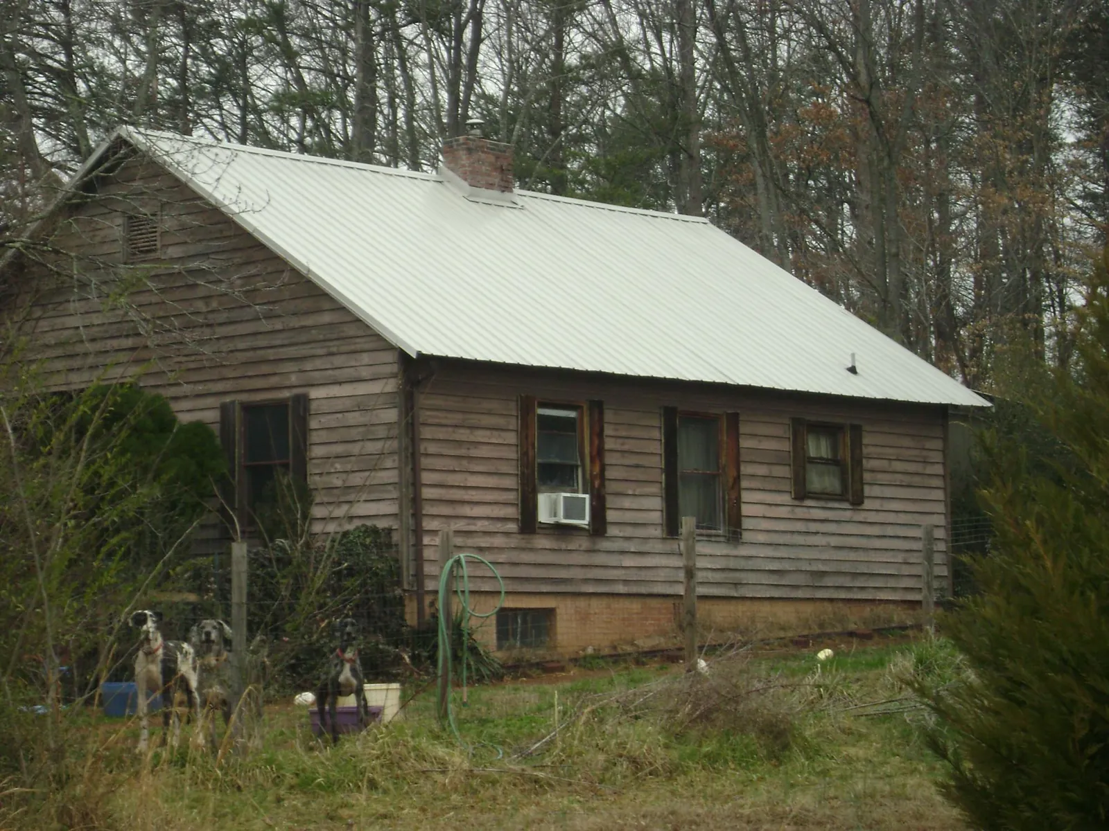 White metal roof on an old wood sided farmhouse, from a Metal Roof Installation job in Pentwater