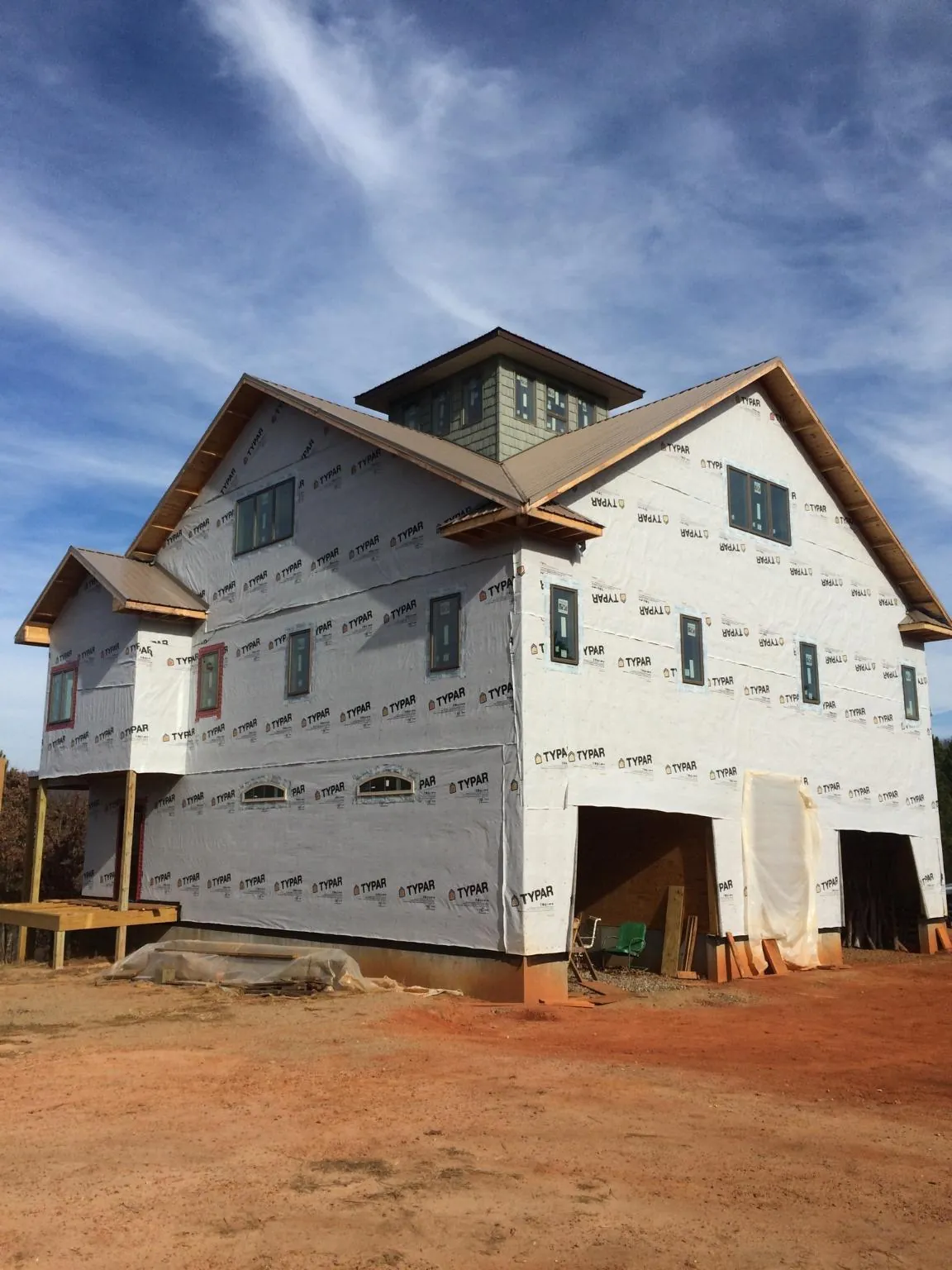 New two story house under construction with a cupola and gabled roofs in Pentwater